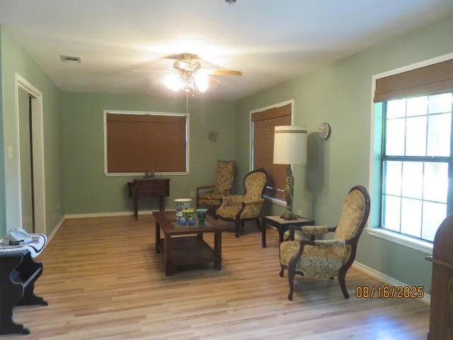 a living room with furniture a window and wooden floor
