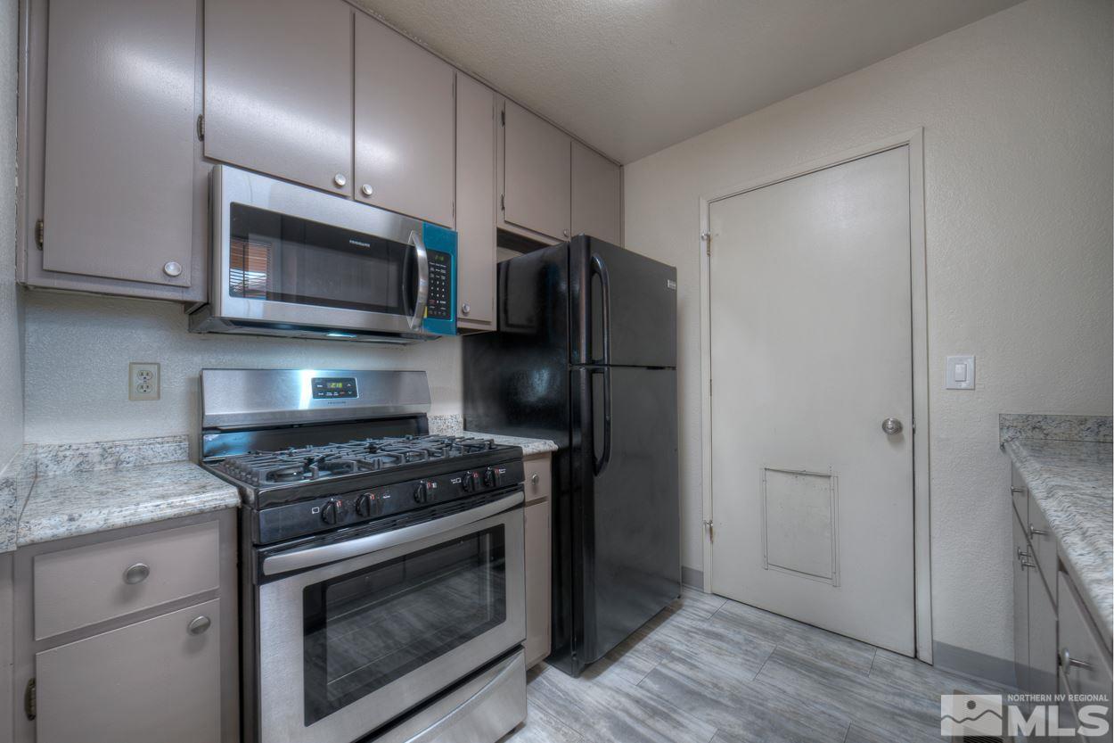 10034 Humite Lane Reno, NV 89506 - Photo 12 of 21 a kitchen with stainless steel appliances granite countertop a stove a refrigerator and a microwave