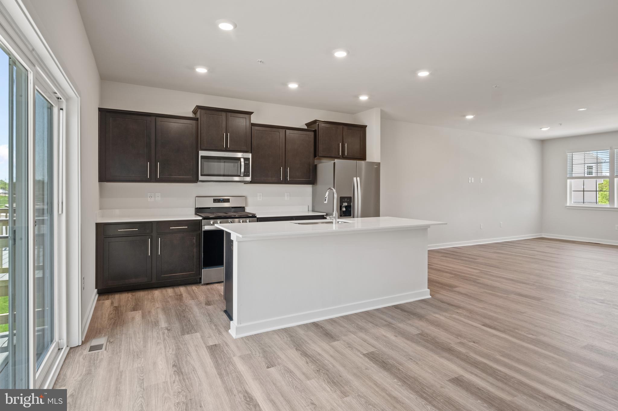 5019 Silver Oak Drive Rosedale, MD 21237 - Photo 9 of 43 a kitchen with stainless steel appliances kitchen island granite countertop a stove a sink and a refrigerator