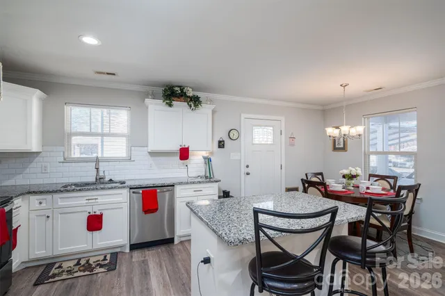 a view of a kitchen area with furniture and wooden floor