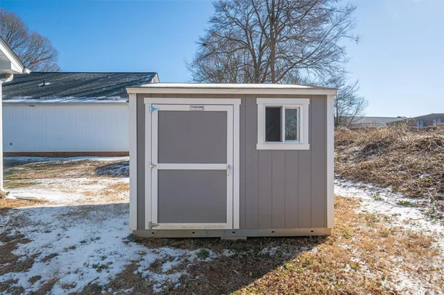 a backyard of a house with wooden fence and trees