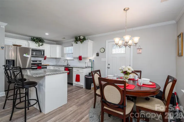 a kitchen that has a dining table and chairs