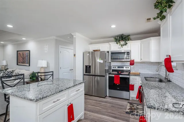 a kitchen with stainless steel appliances granite countertop a refrigerator and a sink