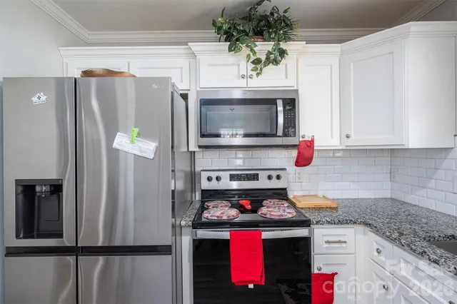 a kitchen with stainless steel appliances granite countertop a refrigerator stove and microwave