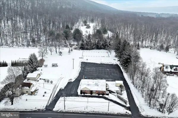 a front view of a house with a yard covered with snow