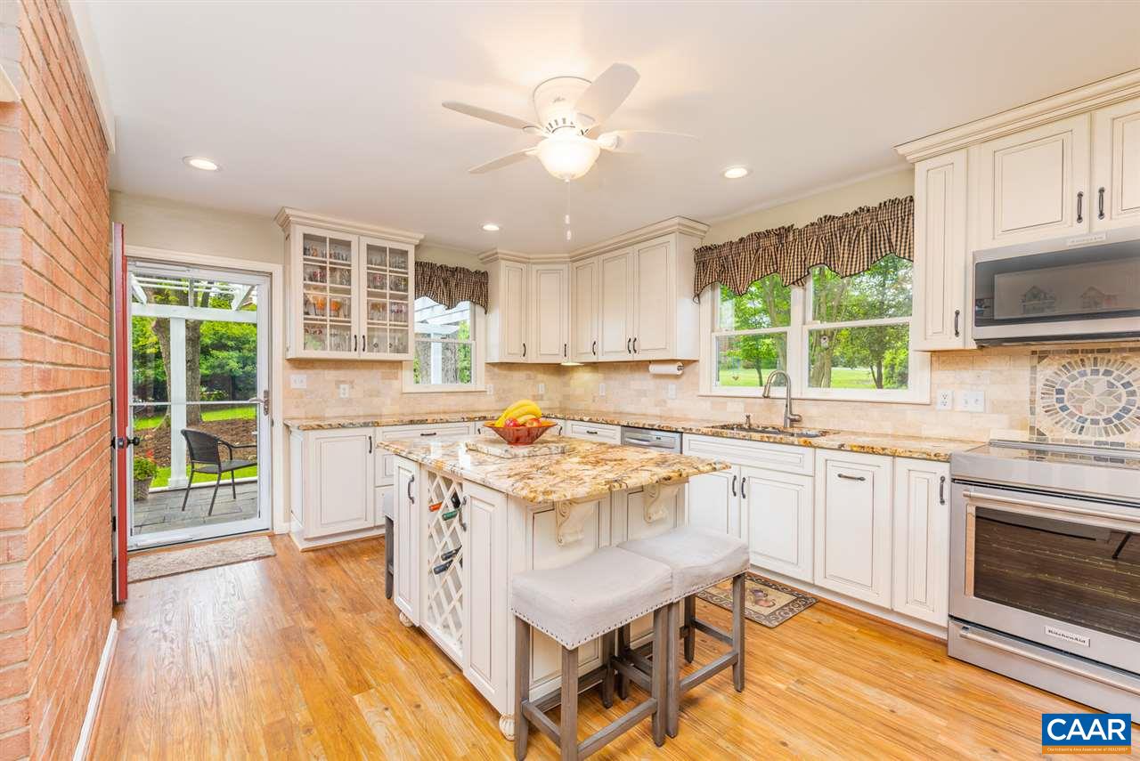 2417 Northfield Road Charlottesville, VA 22901 - Photo 11 of 47 a open kitchen with granite countertop a stove top oven a sink dishwasher and white cabinets with wooden floor
