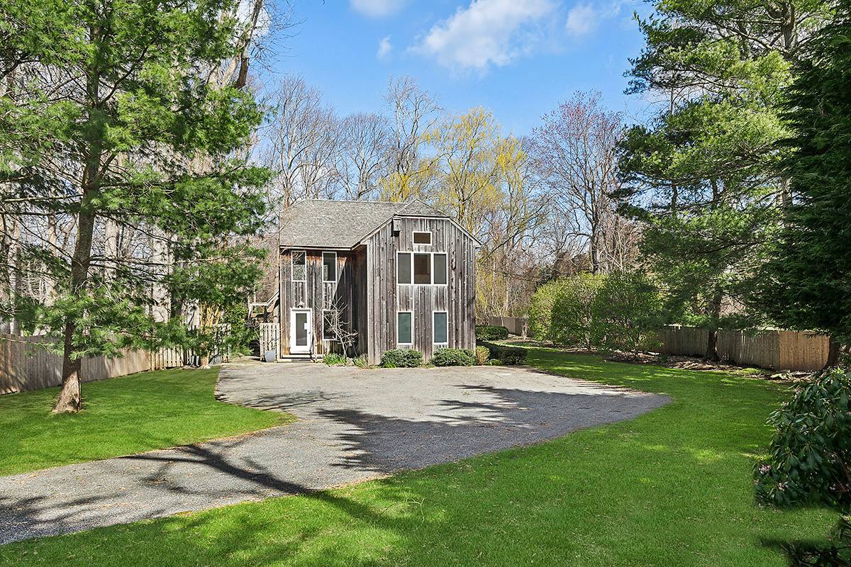 2855 Noyack Road Sag Harbor, NY 11963 - Photo 11 of 13 a front view of a house with a garden