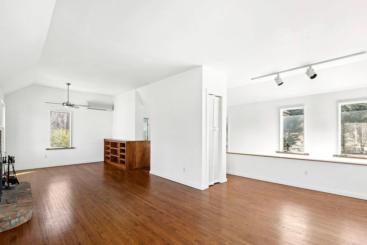 2855 Noyack Road Sag Harbor, NY 11963 - Photo 5 of 13 an empty room with wooden floor and windows