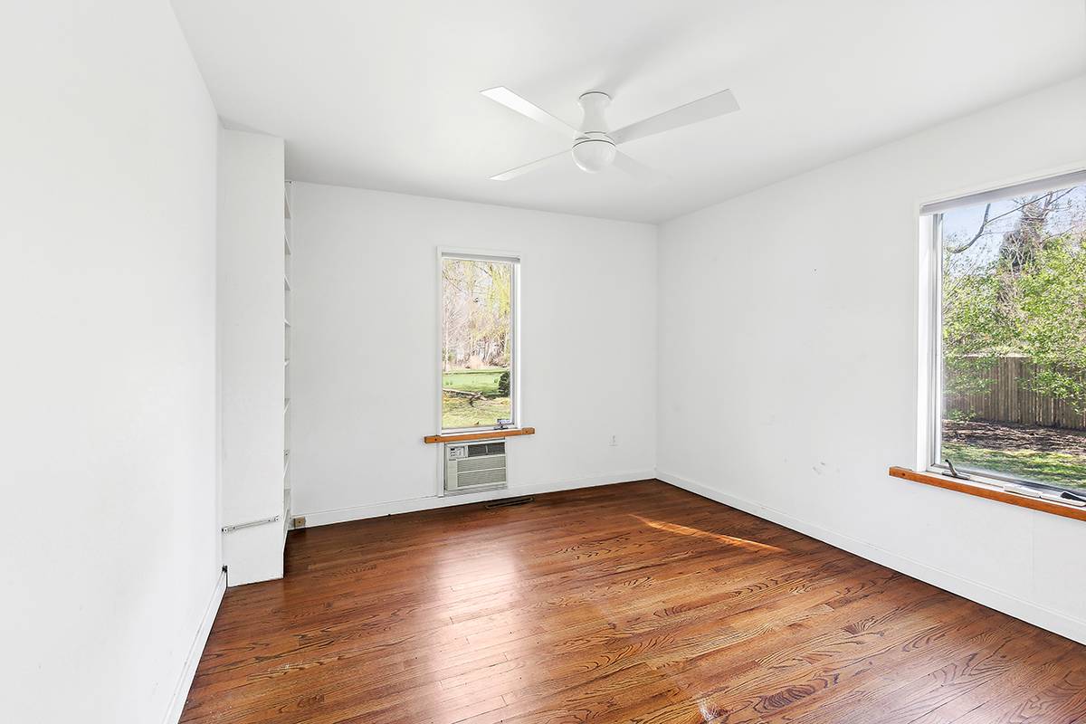 2855 Noyack Road Sag Harbor, NY 11963 - Photo 9 of 13 an empty room with wooden floor and windows