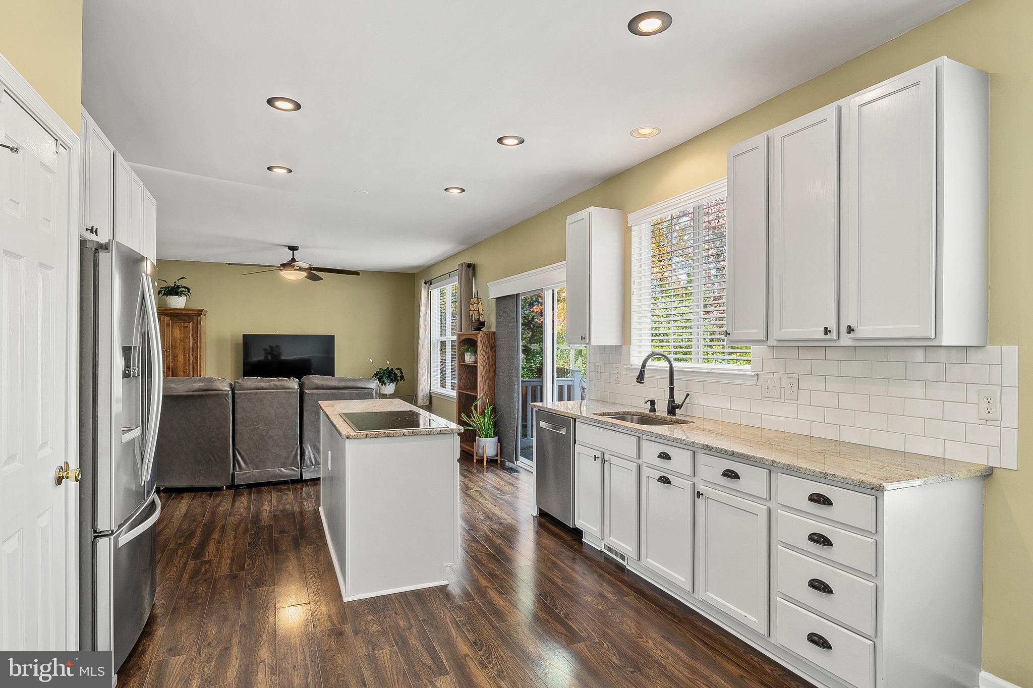 716 Wagner Farm Road Millersville, MD 21108 - Photo 14 of 45 a kitchen with stainless steel appliances a stove top oven a refrigerator a sink and white cabinets with wooden floor