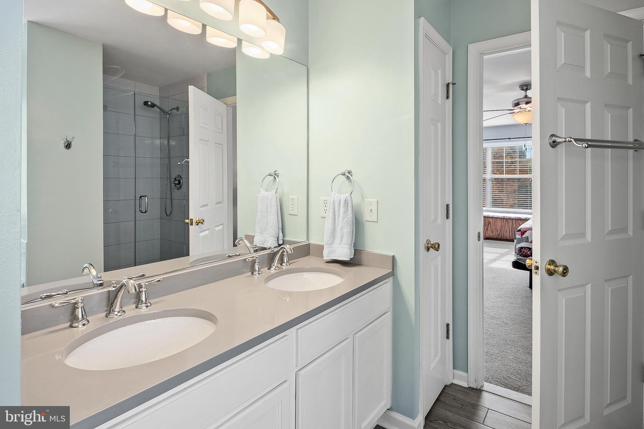 716 Wagner Farm Road Millersville, MD 21108 - Photo 27 of 45 a bathroom with a granite countertop double vanity sink a mirror and a shower