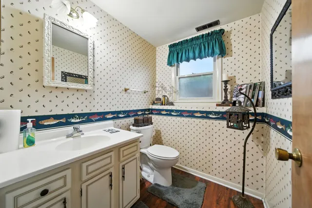 a bathroom with a sink a toilet and mirror