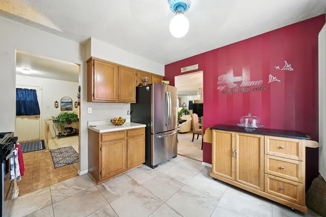 a kitchen with stainless steel appliances granite countertop a refrigerator and a stove top oven