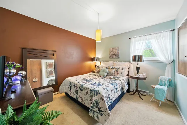 a bedroom with a bed chair and window