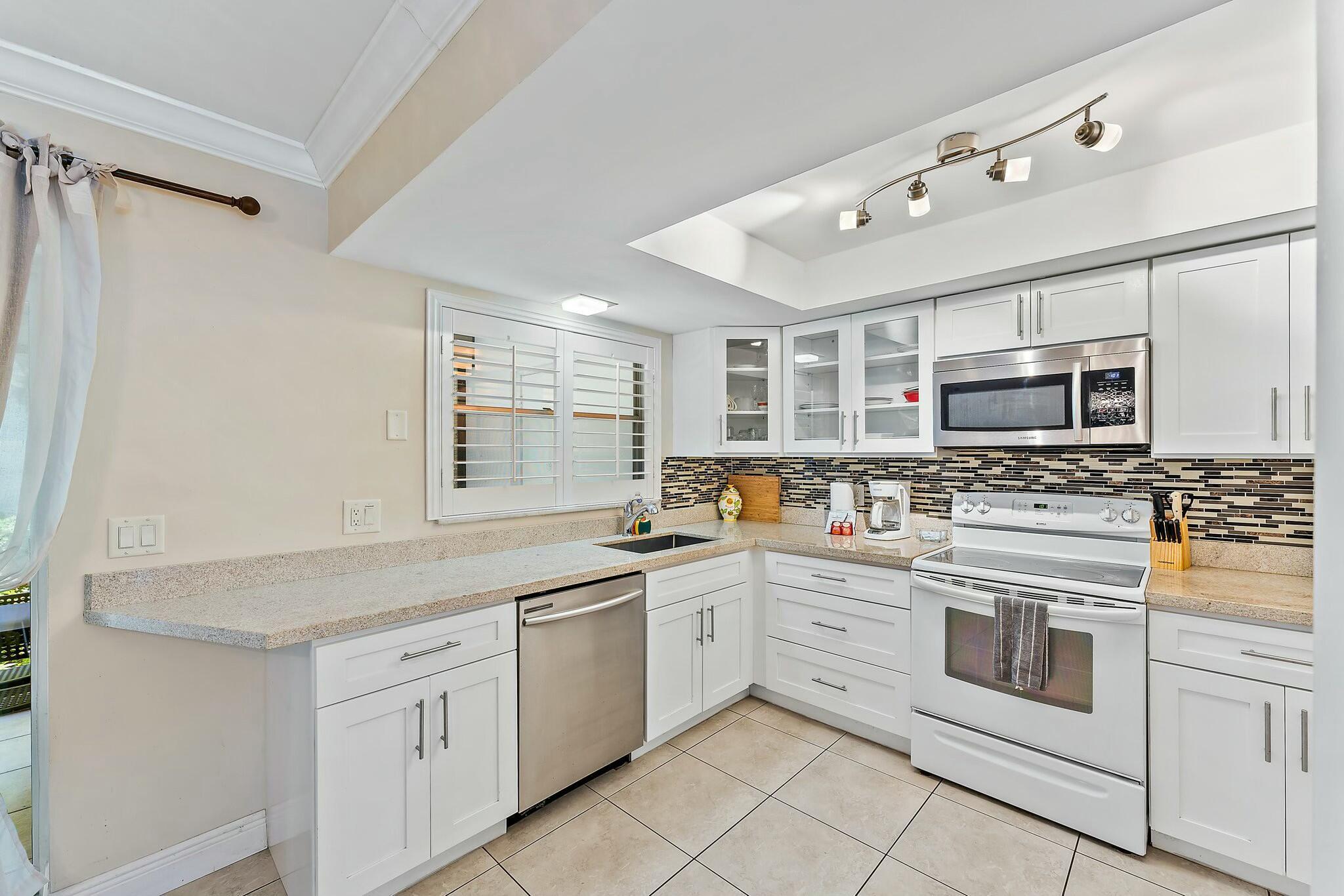 3036 Park Avenue Riviera Beach, FL 33404 - Photo 8 of 22 a kitchen with stainless steel appliances granite countertop a stove and a sink