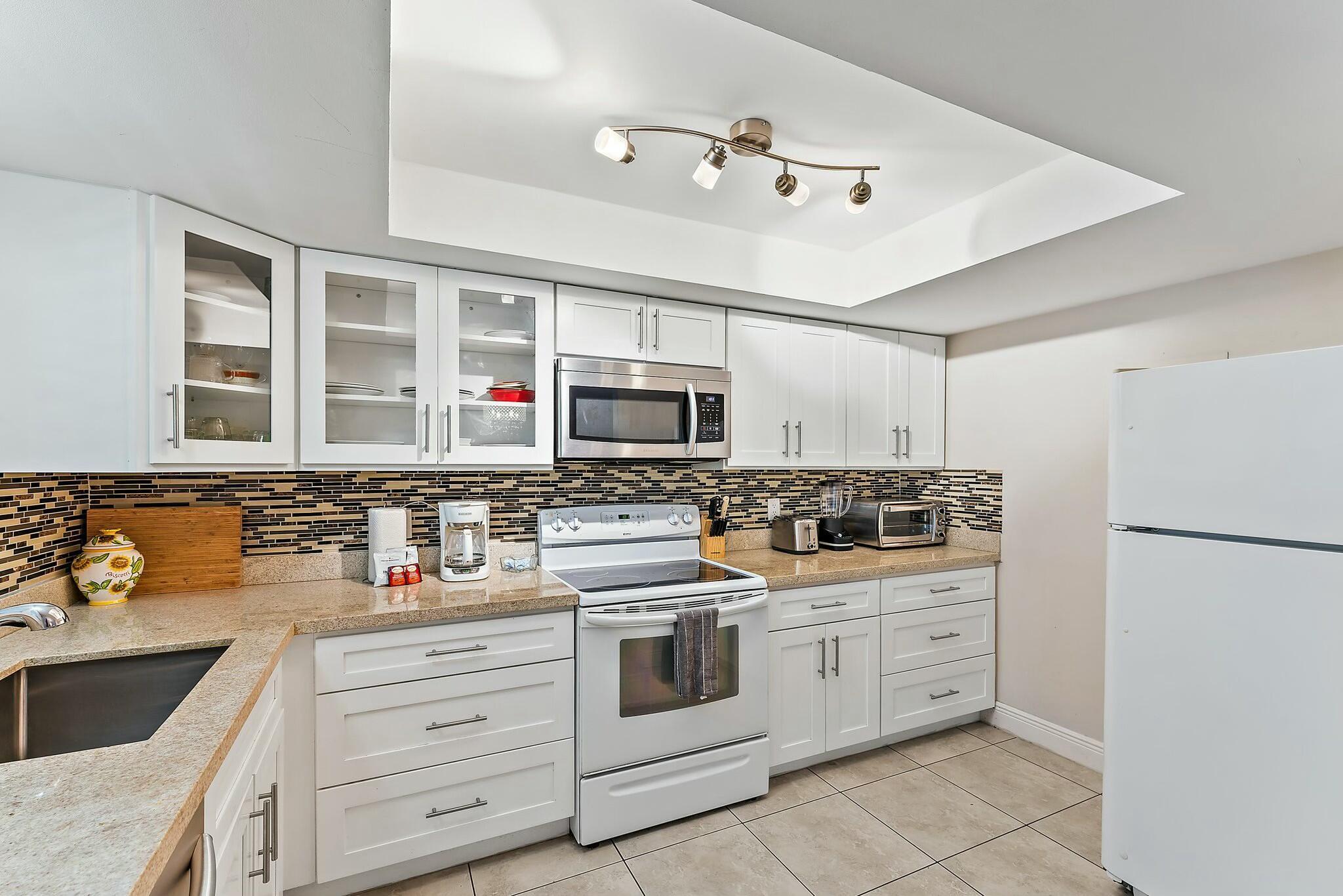 3036 Park Avenue Riviera Beach, FL 33404 - Photo 9 of 22 a kitchen with stainless steel appliances granite countertop a stove and cabinets