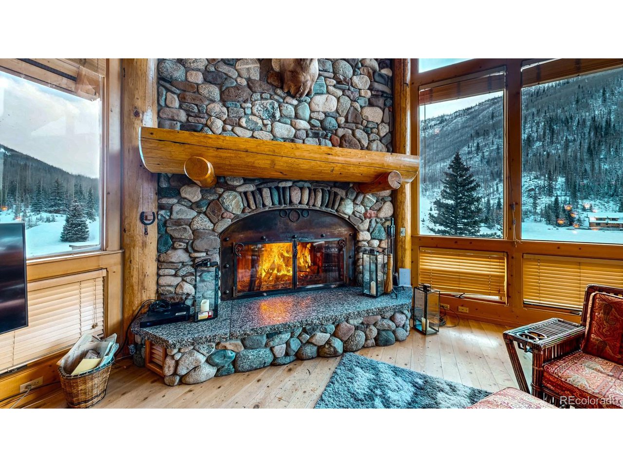 2418 Forest Road Creede, CO 81130 - Photo 3 of 50 a living room with a fireplace a flat screen tv and floor to ceiling window