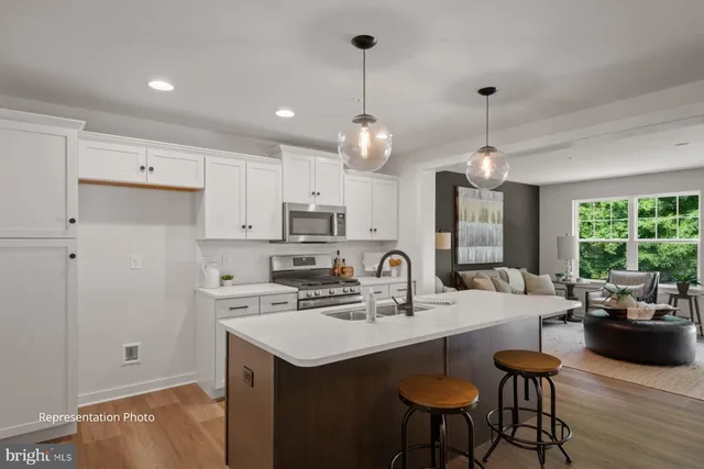 a kitchen with stainless steel appliances kitchen island granite countertop a sink a stove and chairs
