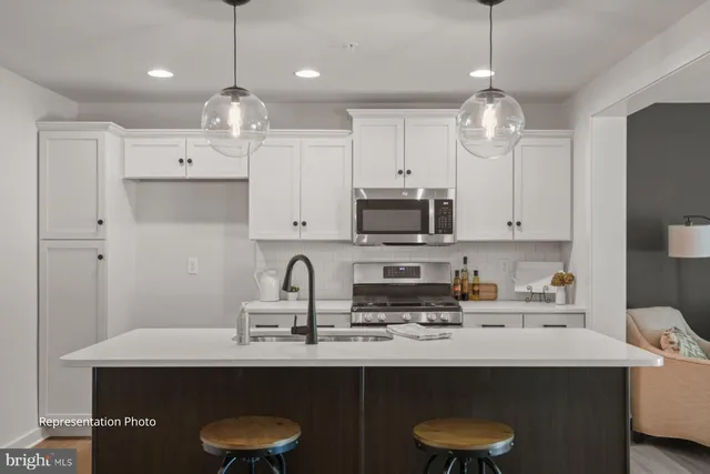 a kitchen with stainless steel appliances a sink a stove a refrigerator and cabinets