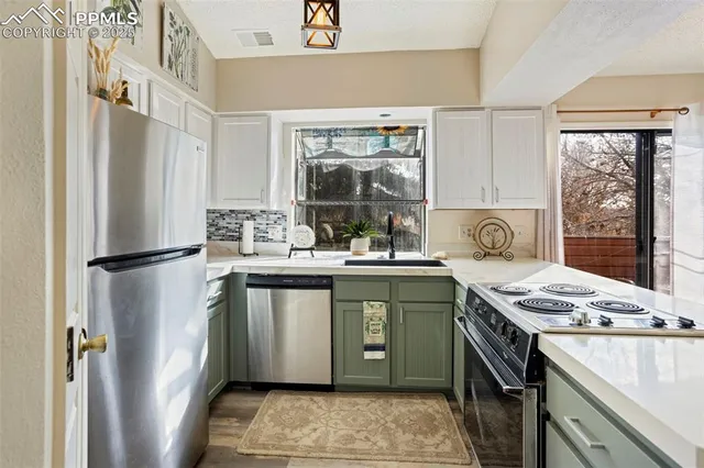 a kitchen with stainless steel appliances granite countertop a stove a refrigerator and a sink