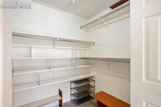 a view of walk in closet with empty racks