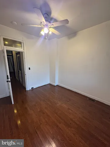 an empty room with wooden floor and chandelier fan