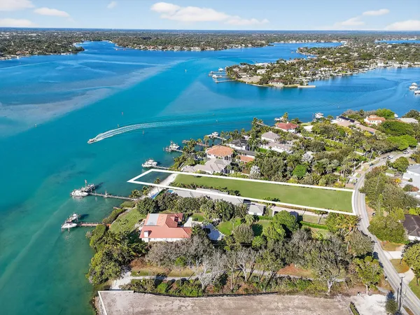 an aerial view of ocean and residential houses with outdoor space