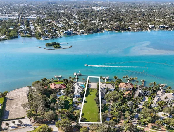 an aerial view of a residential houses with outdoor space and parking