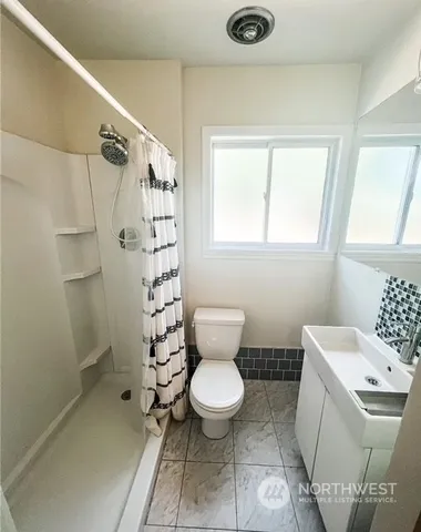 a white toilet sitting next to a bathroom sink and vanity