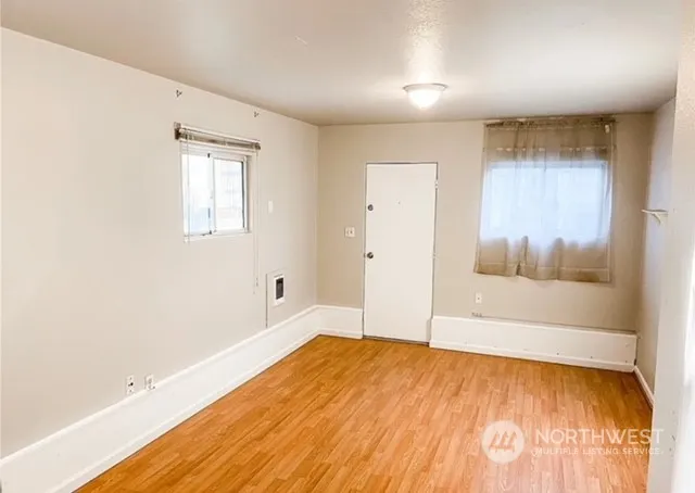 a view of empty room with wooden floor