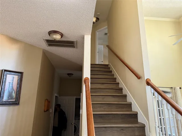 a view of staircase with lots of frames on wall and a window