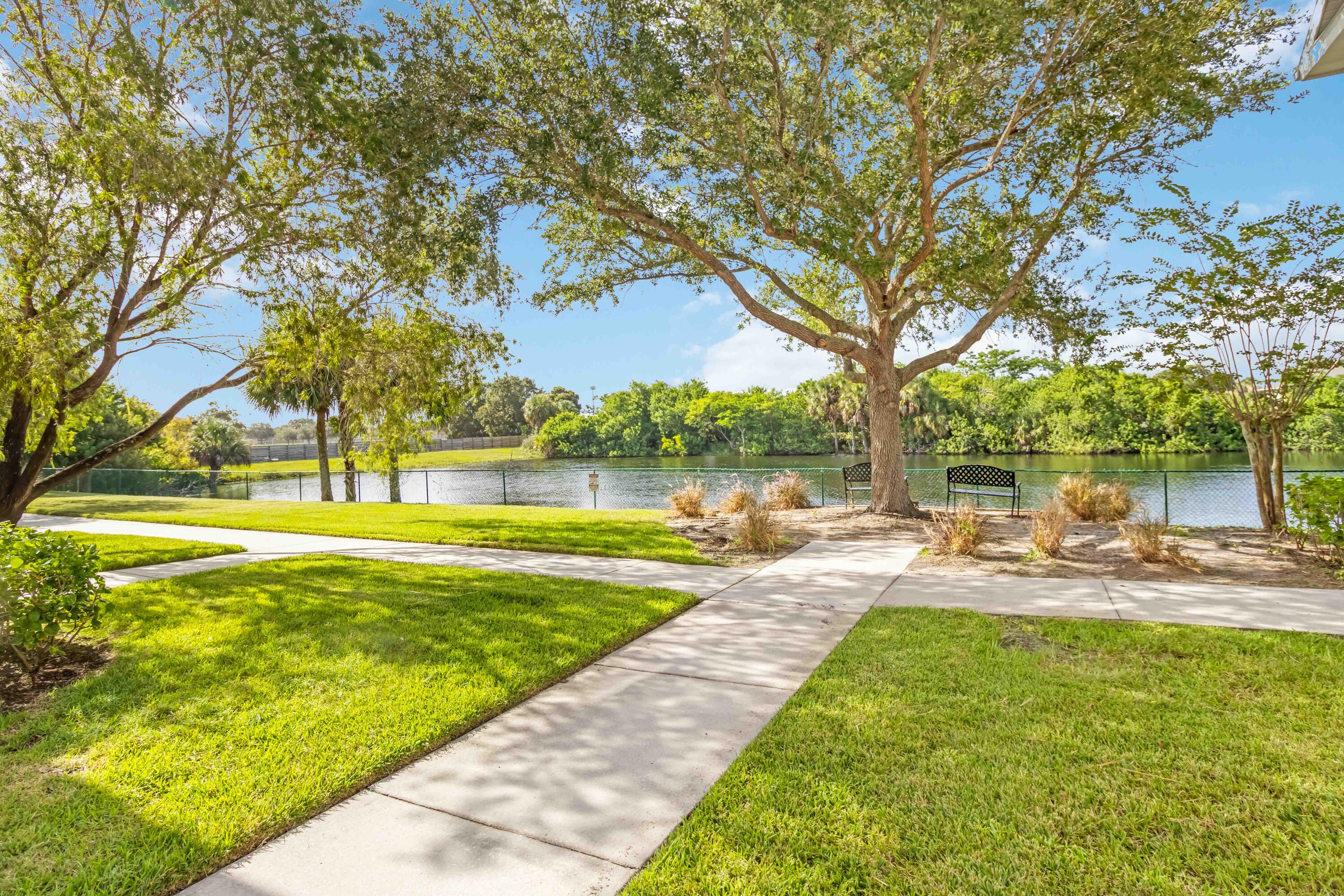 110 Turpial Way, Unit 102 Melbourne, FL 32901 - Photo 11 of 14 a view of a swimming pool with a patio and a yard