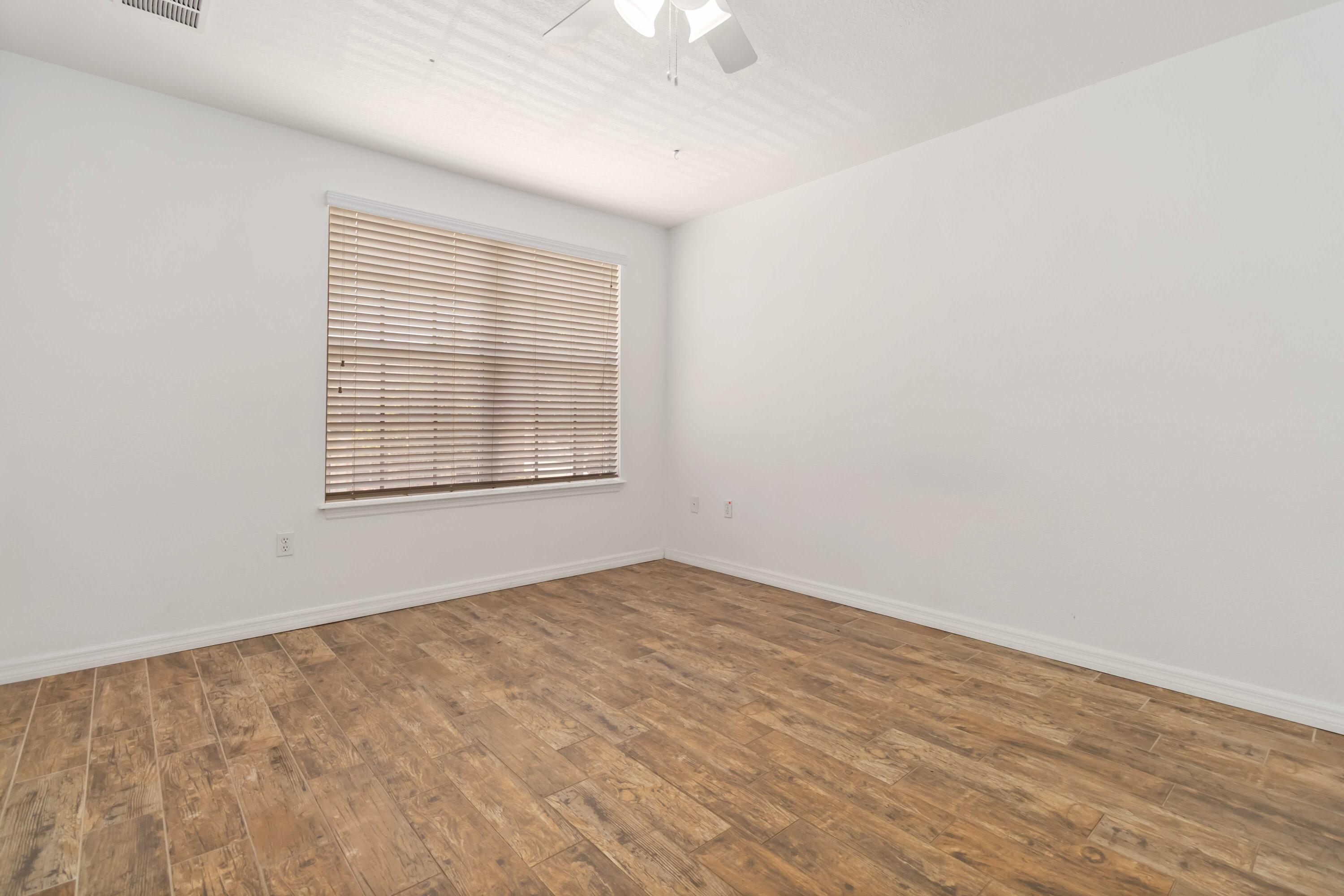 110 Turpial Way, Unit 102 Melbourne, FL 32901 - Photo 7 of 14 wooden floor in an empty room with a window