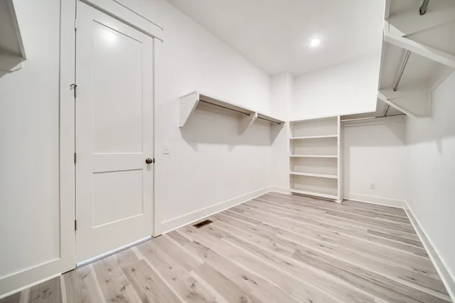 a view of walk in closet with empty racks