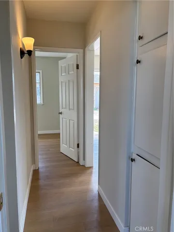 a view of a hallway with wooden floor