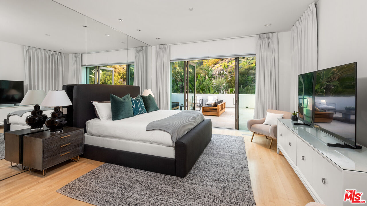 72 Beverly Park Beverly Hills, CA 90210 - Photo 32 of 38 a bedroom with a bed a flat screen tv and a couch