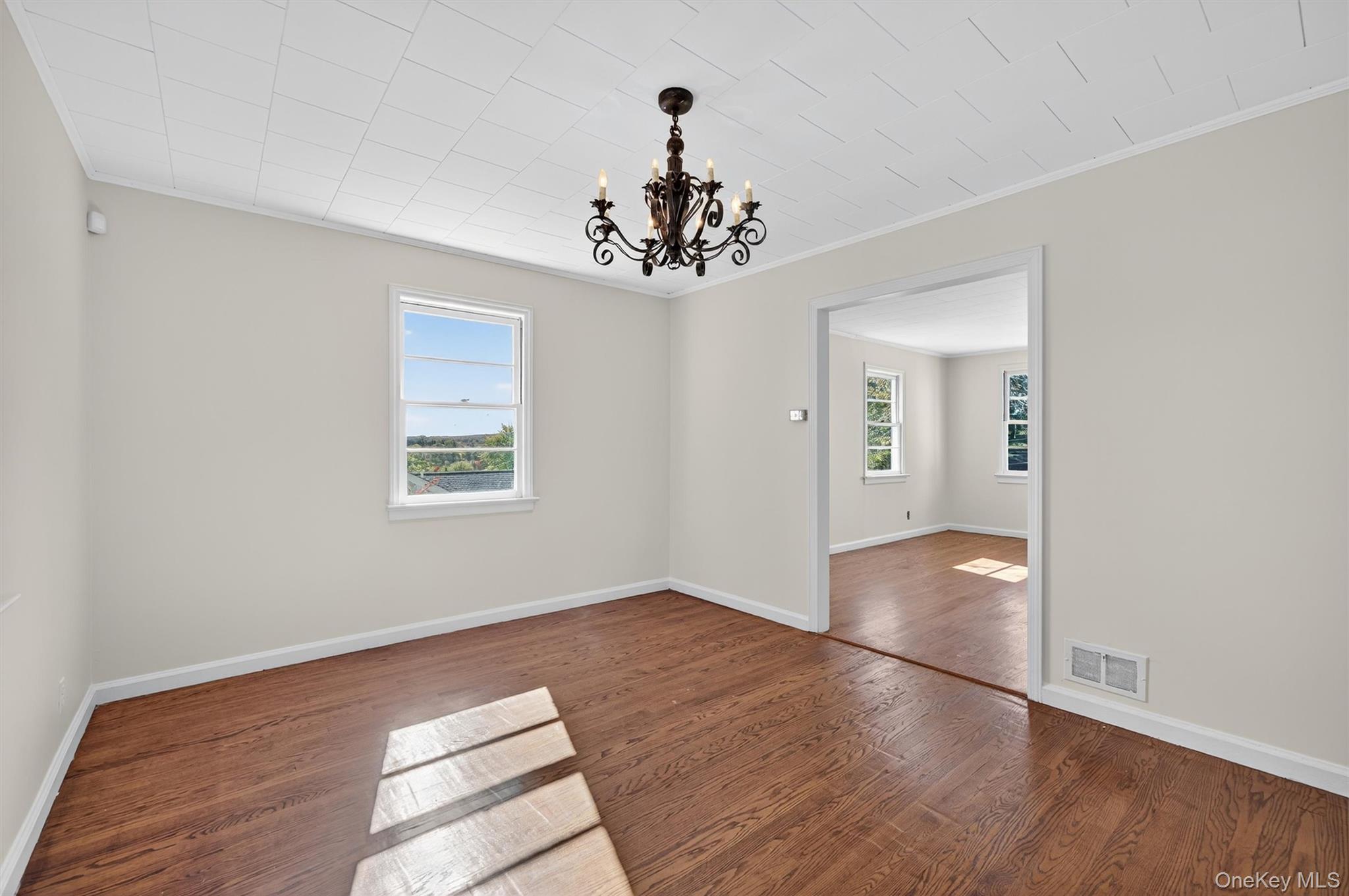 12 Mid Oaks Road Monroe, NY 10950 - Photo 17 of 44 Unfurnished room with a chandelier, dark wood-style floors, crown molding, and plenty of natural light