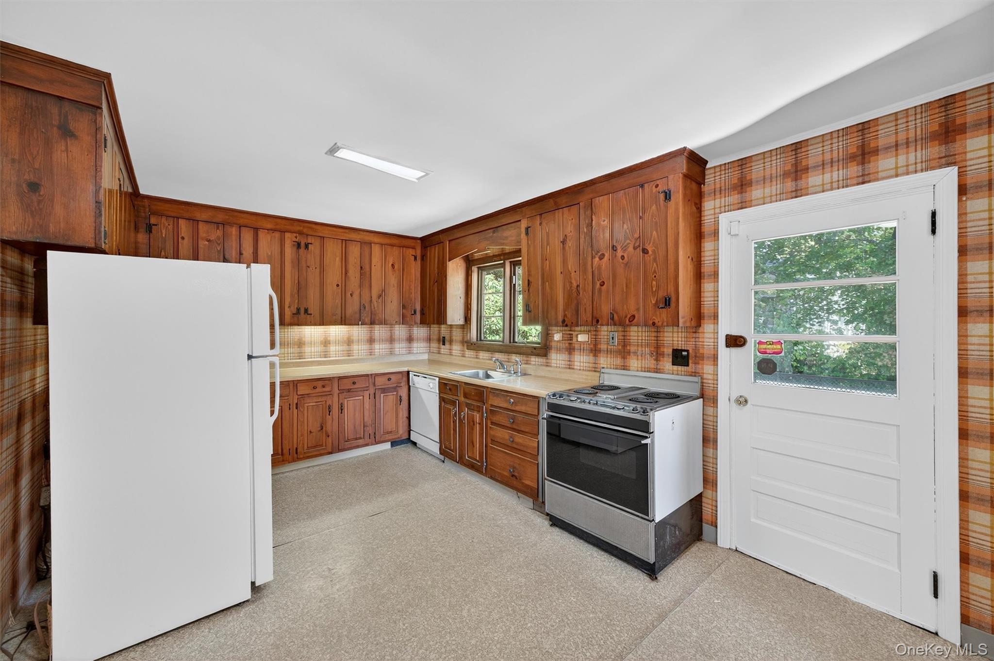 12 Mid Oaks Road Monroe, NY 10950 - Photo 8 of 44 Kitchen with white appliances, light countertops, brown cabinets, light floors, and wood walls
