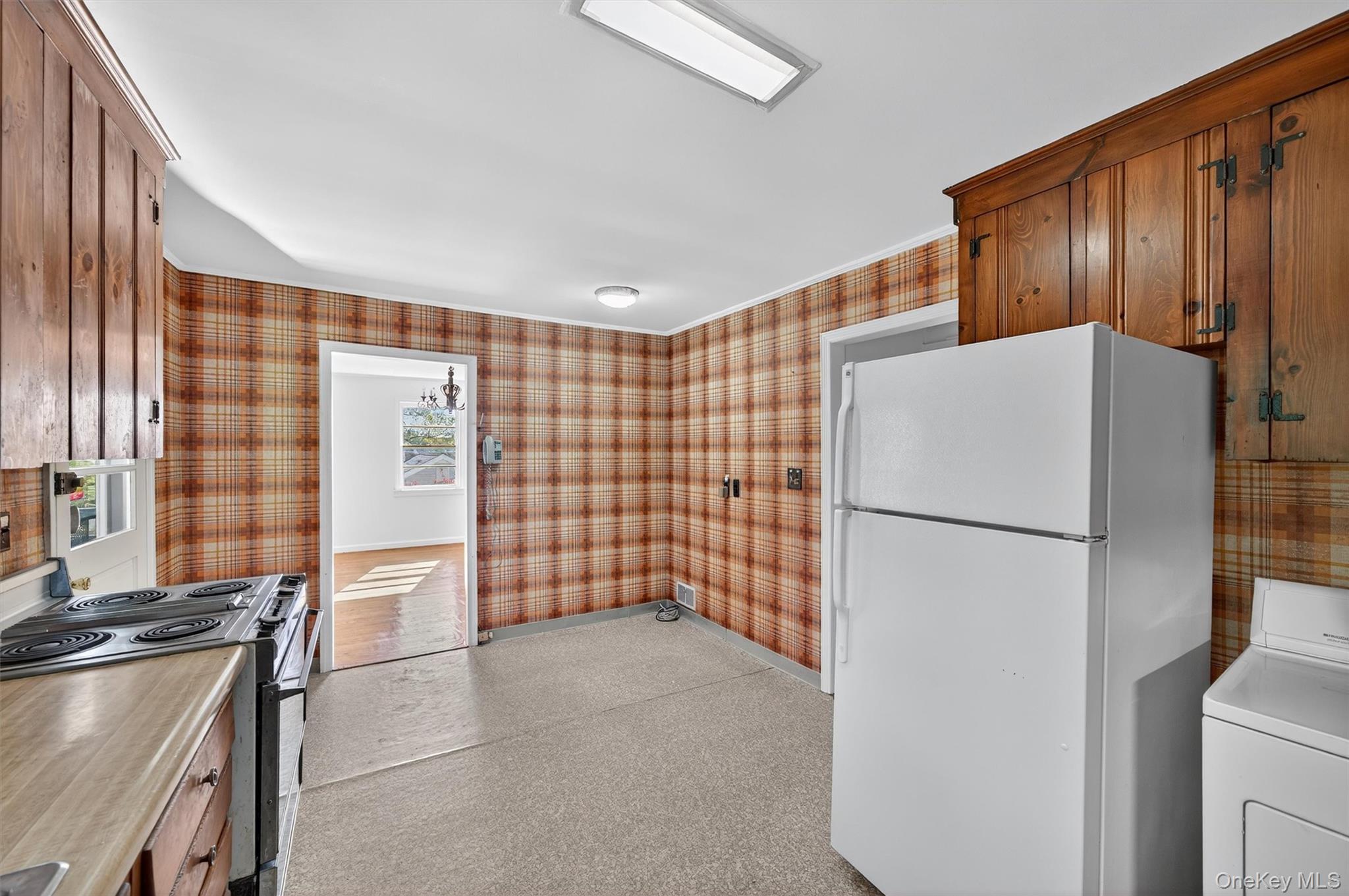 12 Mid Oaks Road Monroe, NY 10950 - Photo 9 of 44 Kitchen with washer / dryer, freestanding refrigerator, stainless steel range with electric stovetop, wallpapered walls, and light countertops
