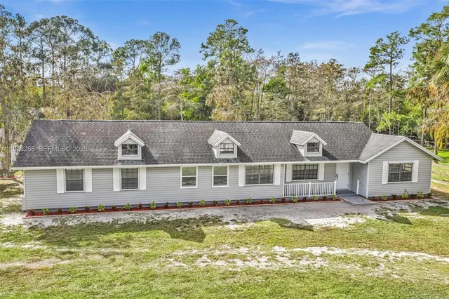 an aerial view of a house with swimming pool in front of it