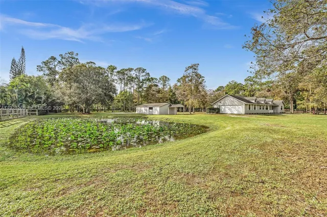 an aerial view of a house with a yard and lake view
