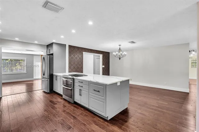 a open kitchen with kitchen island a sink stove and refrigerator