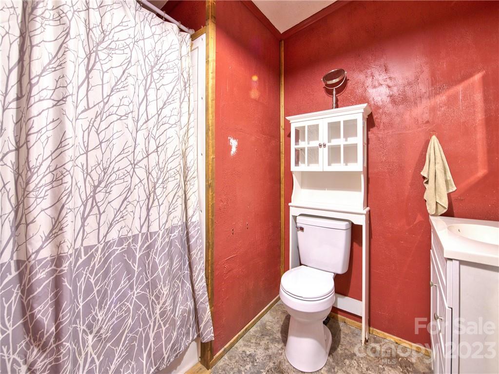 994 Indian Springs Road Clyde, NC 28721 - Photo 34 of 39 a bathroom with a toilet sink and mirror