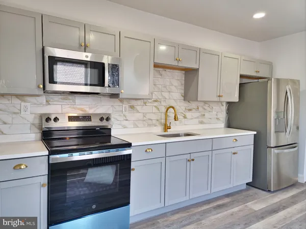 a kitchen with cabinets stainless steel appliances and a counter space