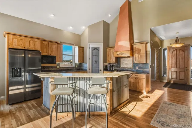 a kitchen with stainless steel appliances granite countertop a stove a sink a refrigerator and cabinets