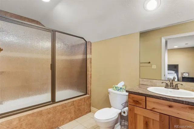 a bathroom with a granite countertop sink toilet and shower