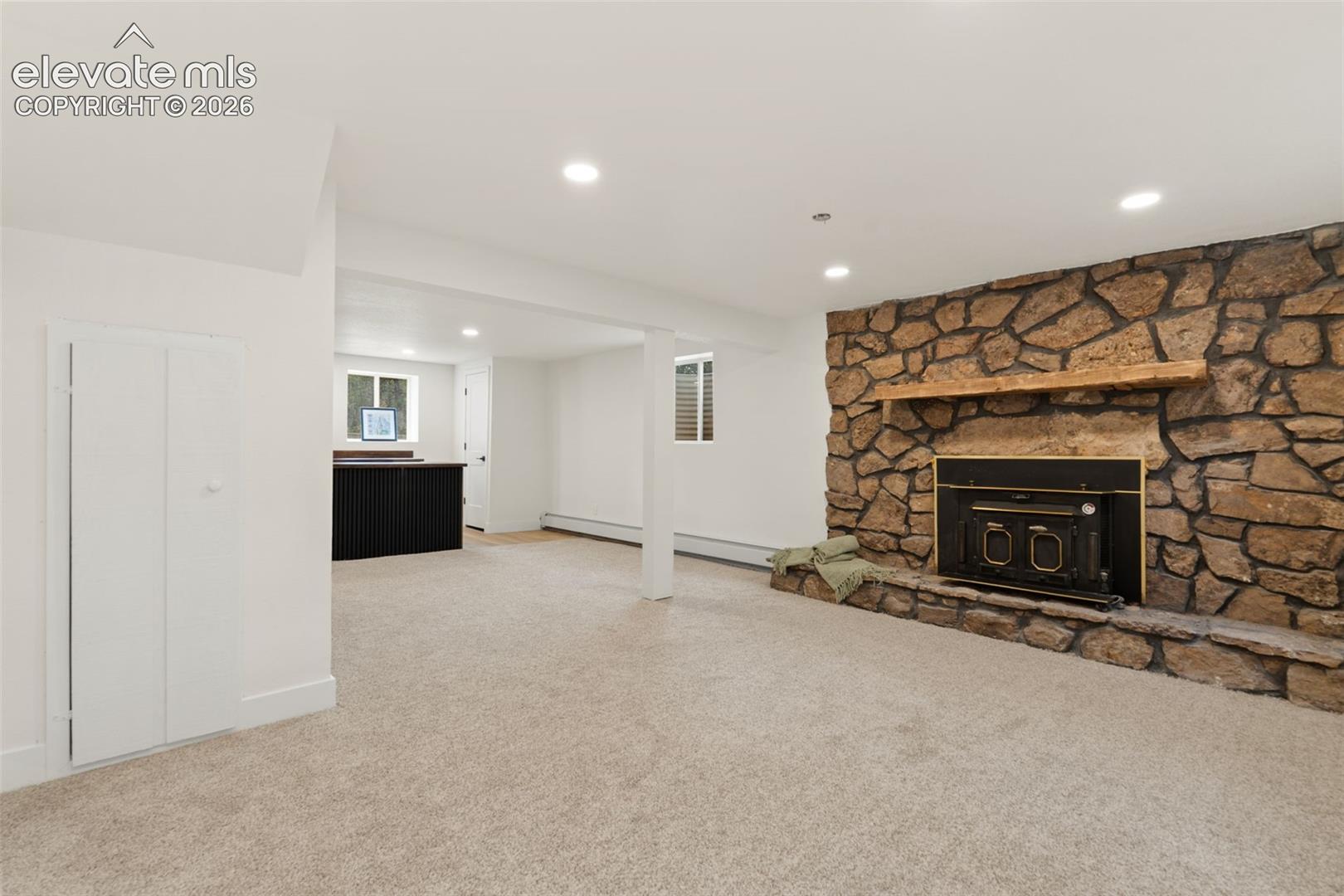 11665 Greentree Road Colorado Springs, CO 80908 - Photo 31 of 43 Unfurnished living room featuring recessed lighting, light carpet, and a fireplace