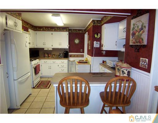 86 West Hill Road Colonia, NJ 07067 - Photo 3 of 10 a kitchen with a refrigerator and a wooden cabinets