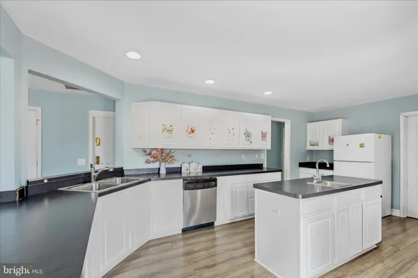 a kitchen with stainless steel appliances a sink a stove top oven a counter space and cabinets