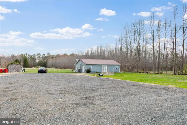 a view of a house with a yard and a large parking space